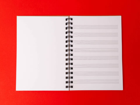 Inside a music manuscript notebook, with a blank page on the left side, and music manuscript on the right. It's A5 in size and has wirobinding.